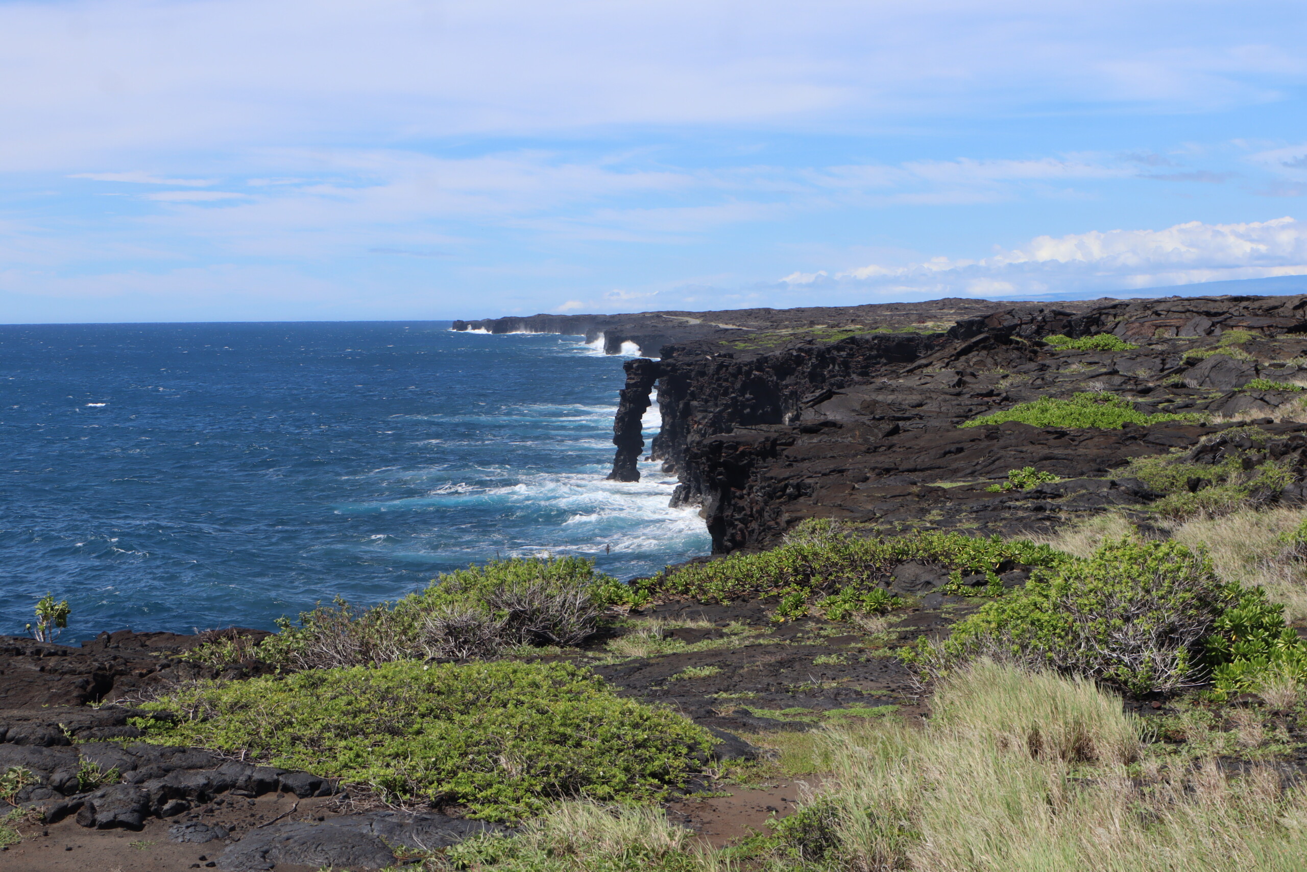 Hōlei Sea Arch standing along a black volcanic coastline